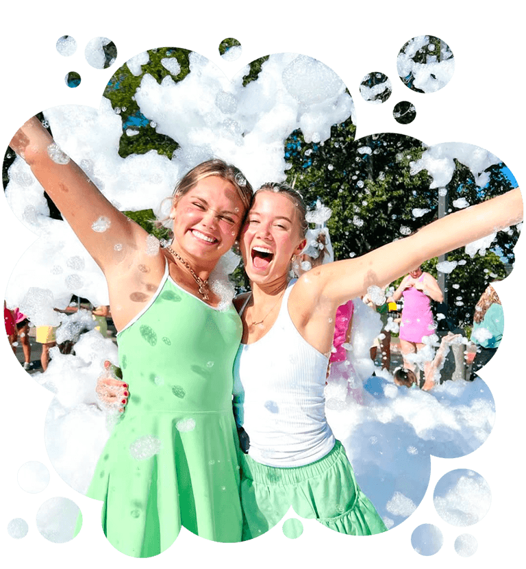 Two young women posing in foam at a family event